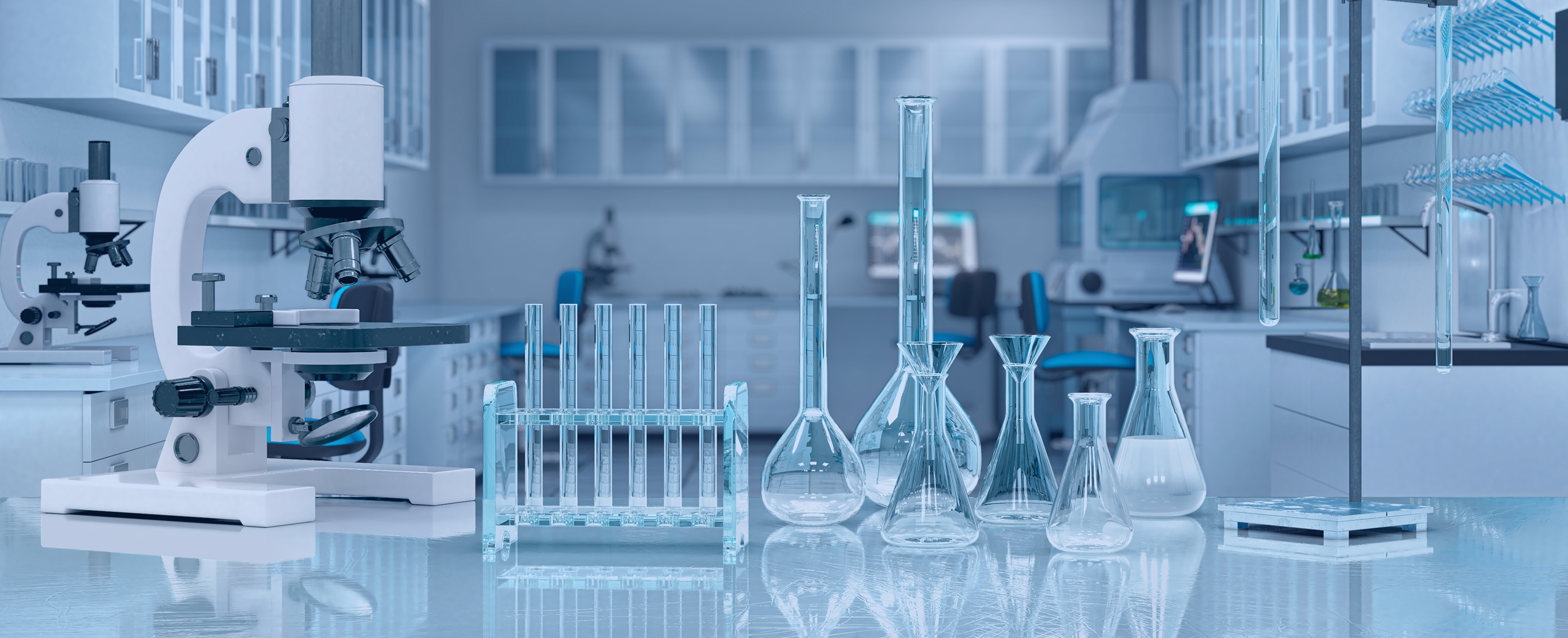 Modern laboratory bench with a microscope and neatly arranged glassware—test tubes, flasks, beakers, and graduated cylinders—in a bright, sterile lab with cabinets and instruments blurred in the blue-tinted background.