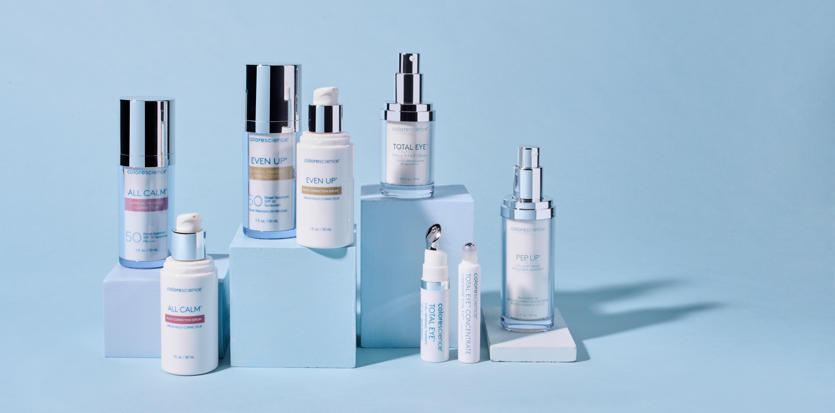 Colorescience skincare bottles and tubes arranged on light blue blocks.
