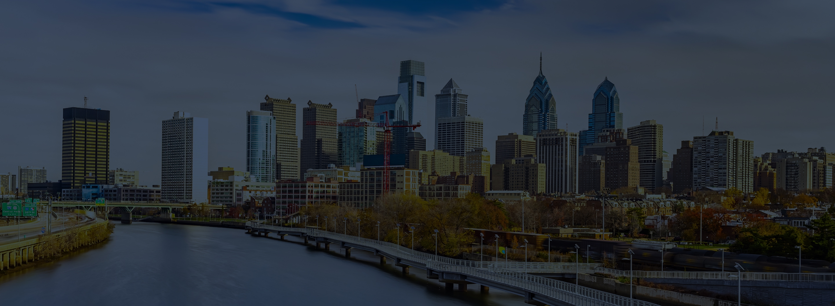 Philadelphia skyline along the Schuylkill River with the boardwalk in the foreground.