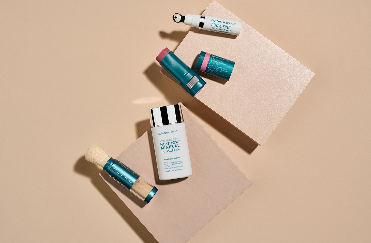 Colorescience sunscreens and Total Eye products arranged on a beige background with geometric blocks.
